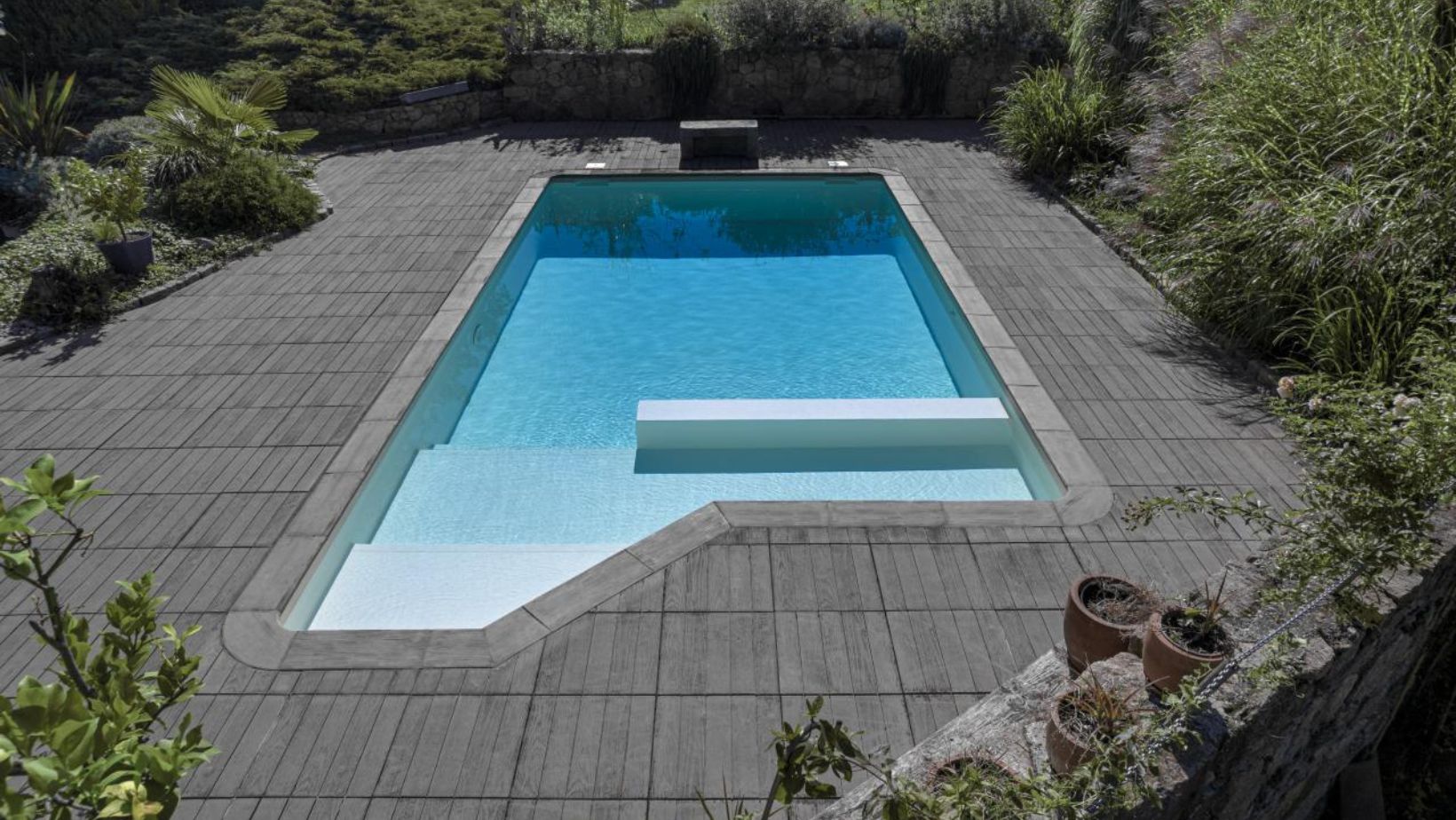 Le cliché illustre une piscine avec un liner blanc, reflet de clarté et de pureté.