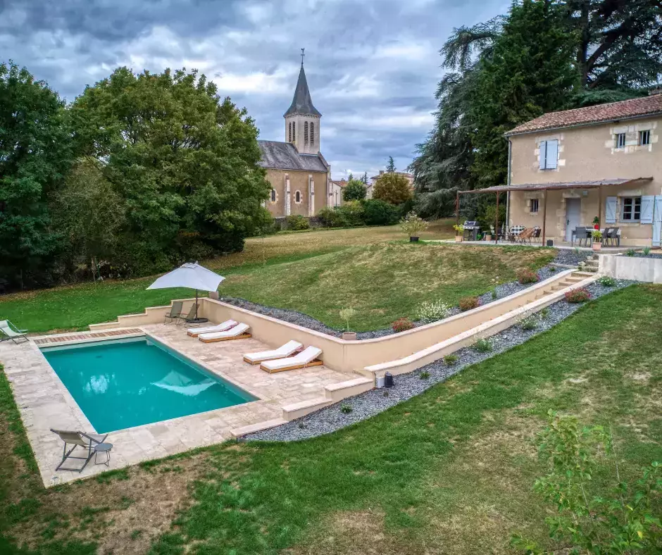 Une piscine d'une élégante couleur olive, entourée d'une terrasse en travertin.