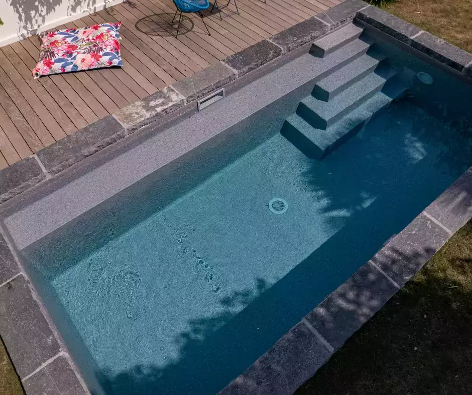 piscine avec des margelles épaisses en pierre en grès d'inde