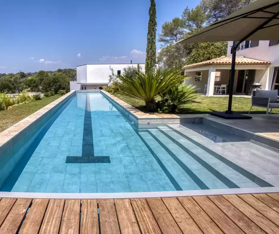  Une piscine couloir de nage conçue en trois espaces avec terrasse et végétation réfléchies.