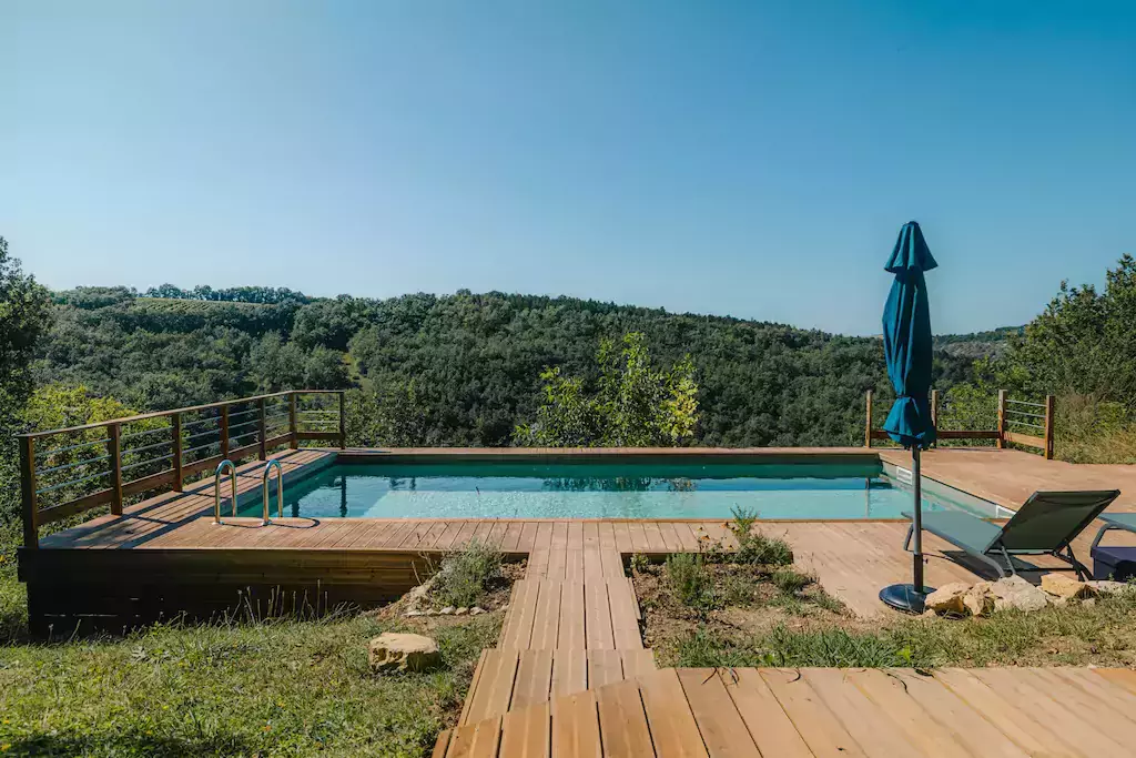 piscine avec terrasse en bois suspendue au dessus d'un champs de tournesol