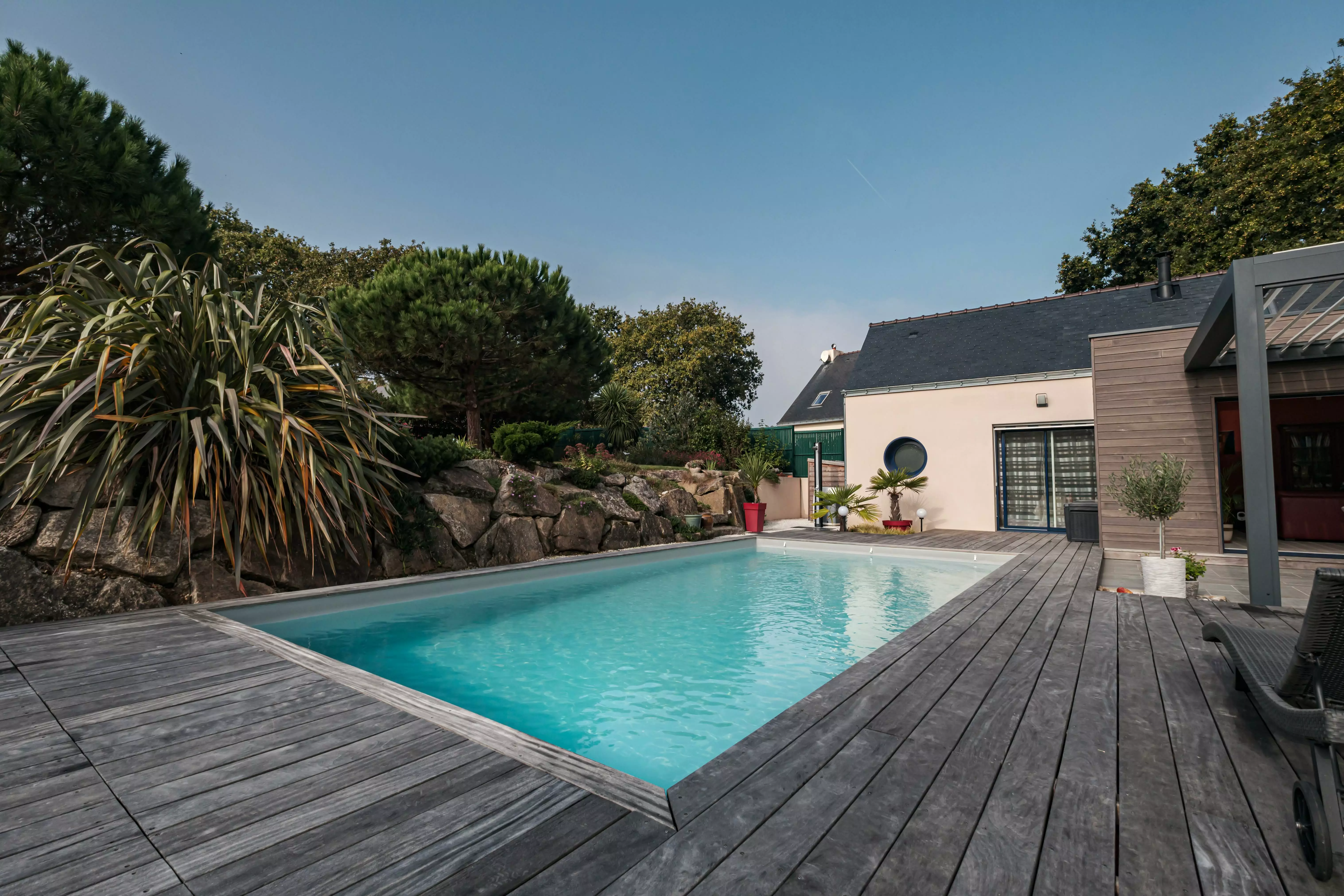 Une construction actuelle valorisant la piscine, adoucie par une terrasse qui conduit à un jardin rocheux agrémenté de touches tropicales.